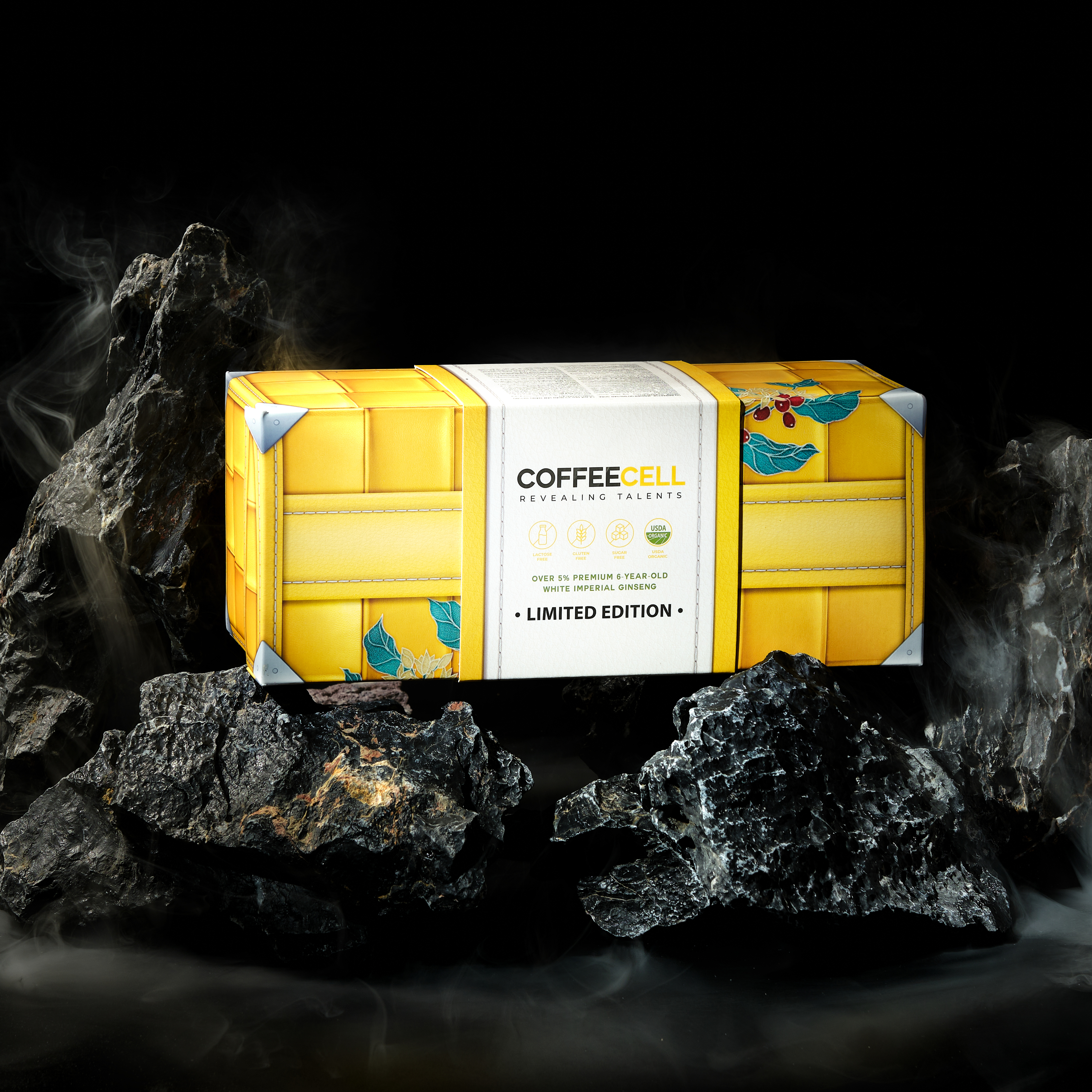 A patterned yellow box of COFFEECELL premium black coffee on rocks
